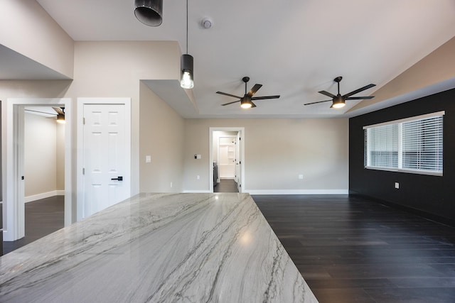 unfurnished room with dark wood-type flooring, ceiling fan, and baseboards