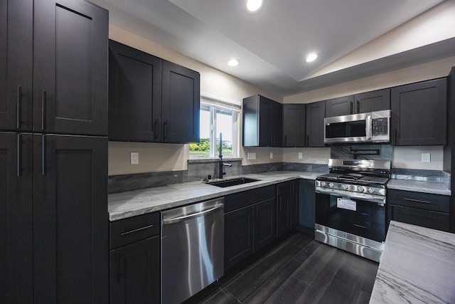 kitchen with stainless steel appliances, recessed lighting, dark wood-type flooring, vaulted ceiling, and a sink