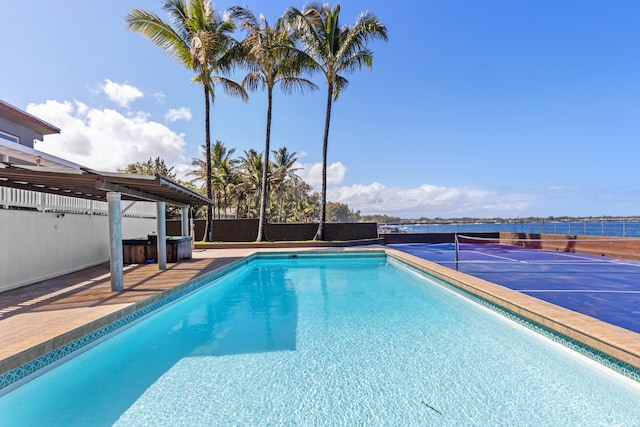 view of pool with a tennis court and fence