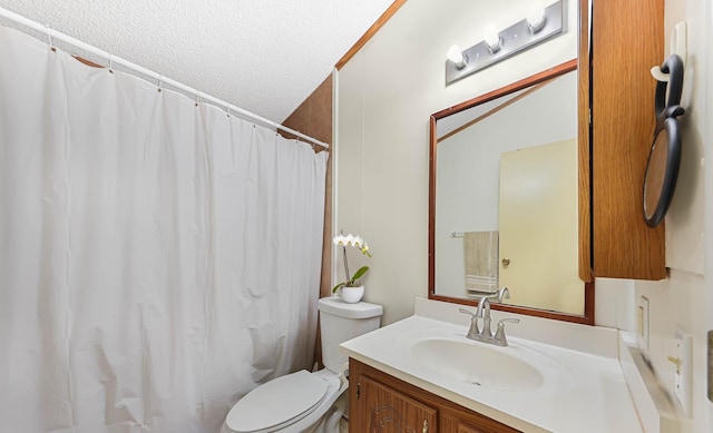 bathroom featuring toilet, a textured ceiling, and vanity