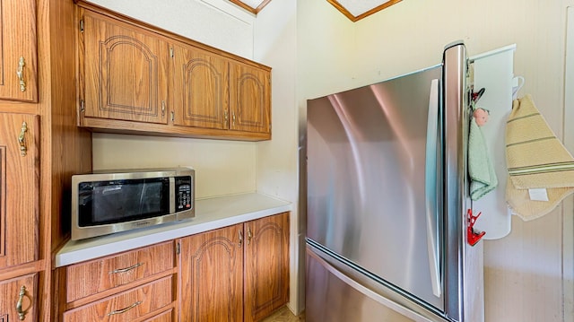 kitchen with appliances with stainless steel finishes, light countertops, and brown cabinetry