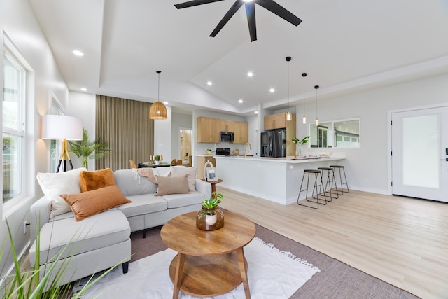 living room with vaulted ceiling, baseboards, light wood-style flooring, and recessed lighting