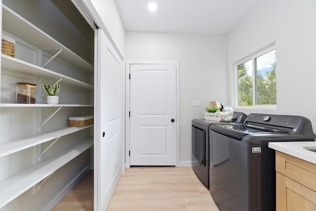 laundry area featuring laundry area, baseboards, washer and dryer, light wood-type flooring, and recessed lighting