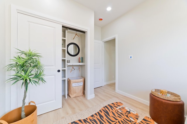 bedroom with a closet, recessed lighting, light wood-style flooring, and baseboards