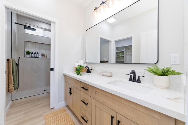 bathroom featuring a walk in shower and vanity