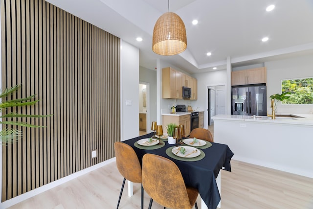 dining room with lofted ceiling, recessed lighting, light wood-style flooring, and baseboards