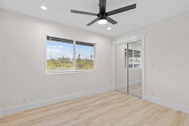 unfurnished bedroom with baseboards, a closet, recessed lighting, and light wood-style floors