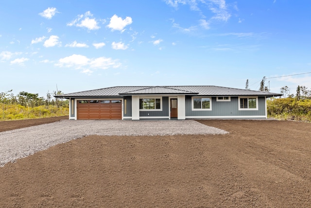 view of front of home with metal roof, driveway, and an attached garage