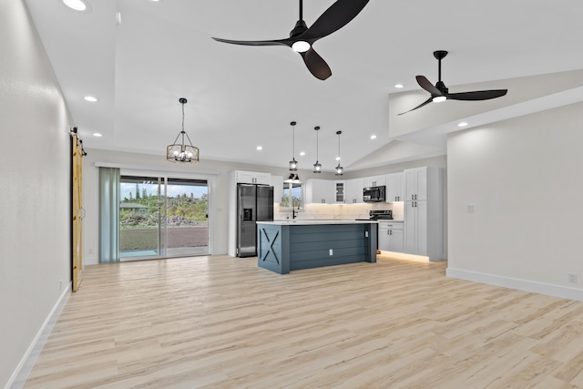 kitchen with decorative light fixtures, stainless steel refrigerator with ice dispenser, light countertops, white cabinetry, and a kitchen island