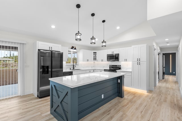 kitchen with stainless steel appliances, glass insert cabinets, white cabinetry, a sink, and a kitchen island