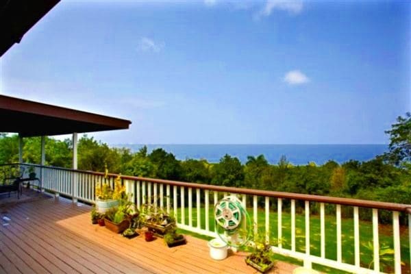 wooden deck featuring a lawn and a water view