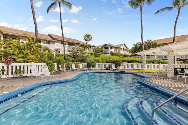 pool with a patio area and fence