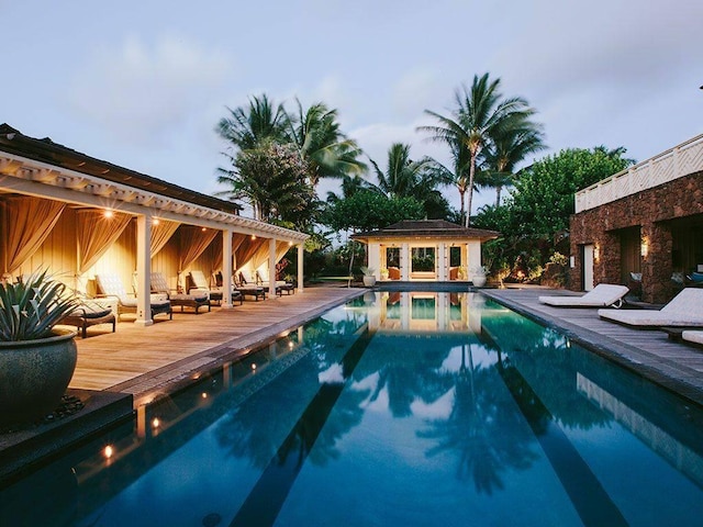 pool with a deck, an outdoor structure, and an exterior structure