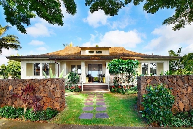 view of front of home with a front yard and covered porch