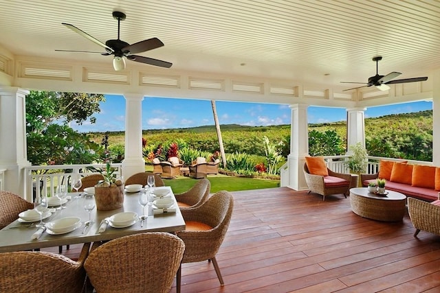 sunroom with decorative columns and a ceiling fan