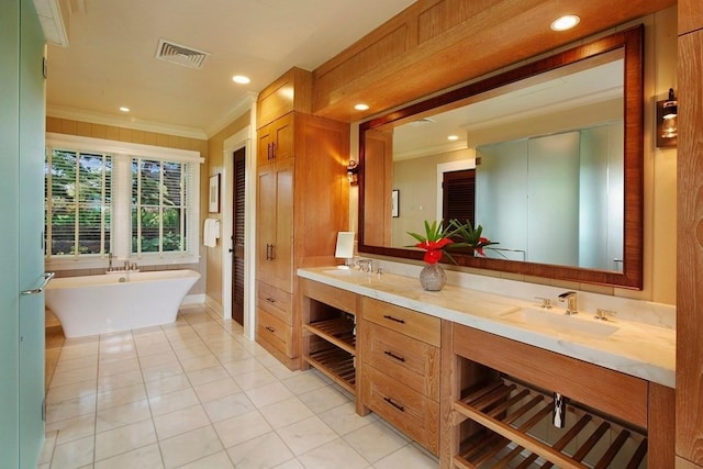 full bathroom with double vanity, visible vents, crown molding, a freestanding bath, and a sink