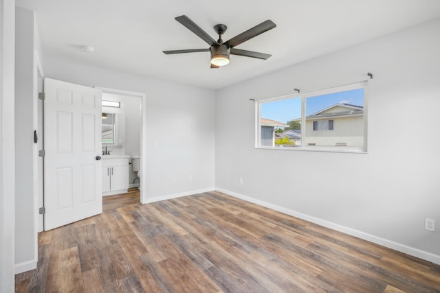 unfurnished bedroom with dark wood-style flooring, ceiling fan, and baseboards