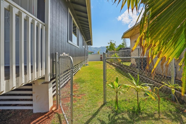 view of yard with a mountain view, fence, and a gate