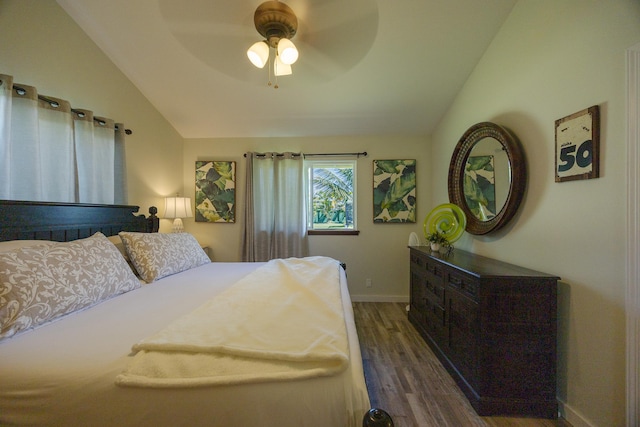 bedroom with a ceiling fan, vaulted ceiling, baseboards, and wood finished floors