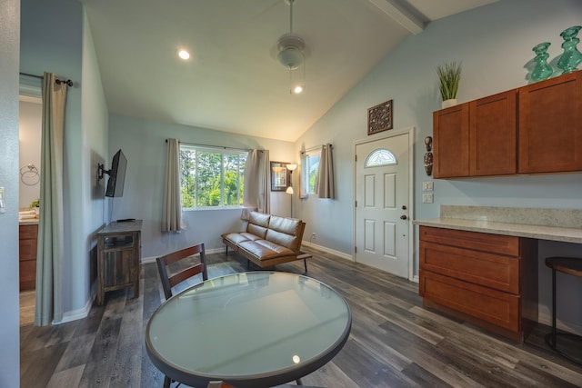 interior space with beam ceiling, built in desk, dark wood-type flooring, high vaulted ceiling, and baseboards