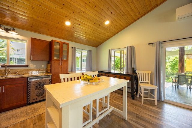 kitchen featuring wooden ceiling, wood finished floors, stainless steel dishwasher, a sink, and a wall mounted AC