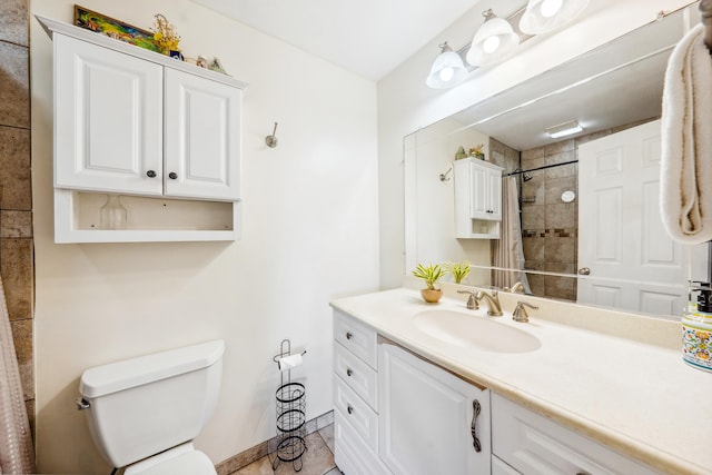 full bath featuring baseboards, tiled shower, vanity, and toilet