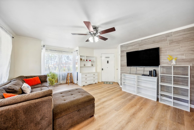 living room with crown molding, ceiling fan, and wood finished floors