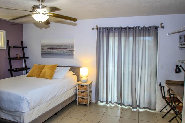 bedroom with ceiling fan, a textured ceiling, and light tile patterned floors