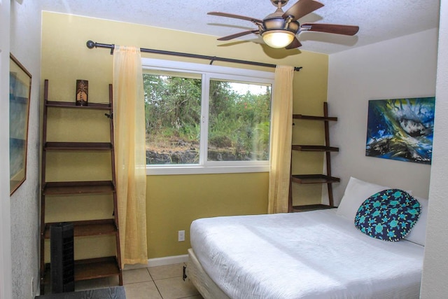 bedroom with light tile patterned floors, ceiling fan, and baseboards