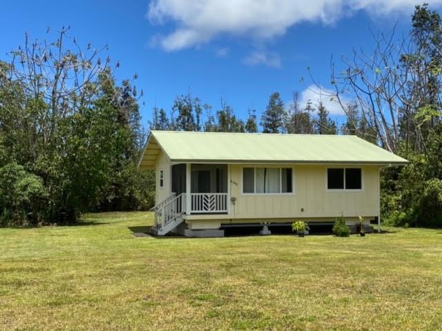 back of house with covered porch and a yard