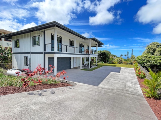 view of home's exterior with a garage, driveway, and a balcony