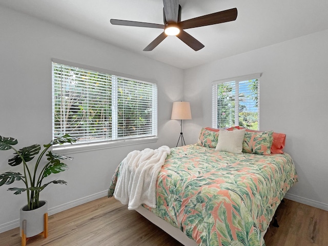 bedroom featuring ceiling fan, wood finished floors, and baseboards