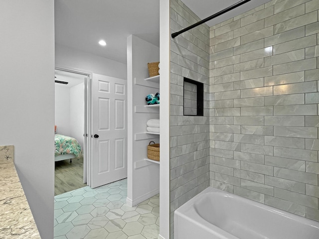 ensuite bathroom with bathtub / shower combination, ensuite bath, and tile patterned floors