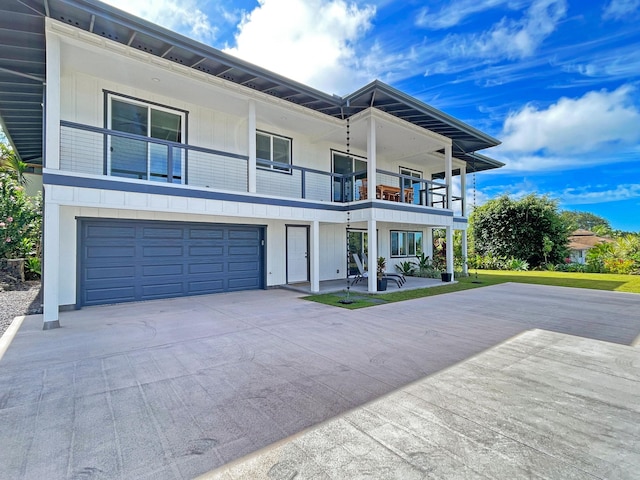 view of front of house featuring driveway, a balcony, and an attached garage