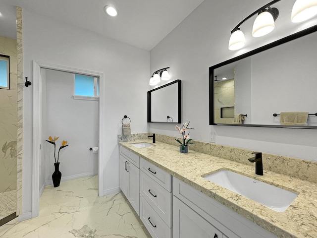 full bath with marble finish floor, a sink, a marble finish shower, and baseboards