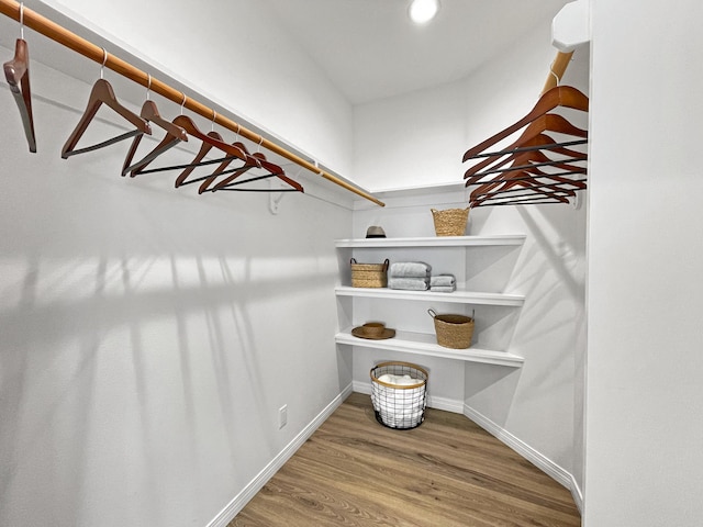 walk in closet with wood finished floors