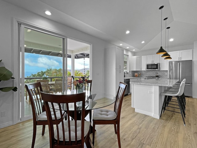 dining area with lofted ceiling, light wood-style flooring, baseboards, and recessed lighting