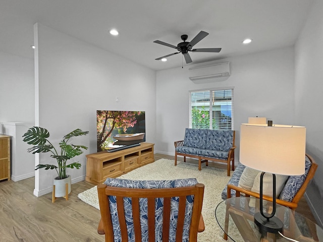 living area featuring a wall unit AC, recessed lighting, ceiling fan, wood finished floors, and baseboards