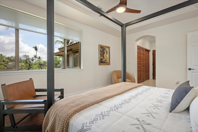 bedroom featuring arched walkways, a closet, and crown molding