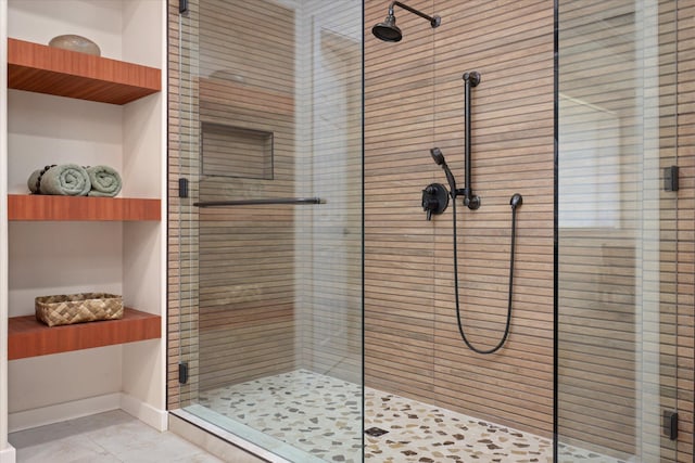 full bathroom featuring baseboards, tile patterned flooring, and a shower stall