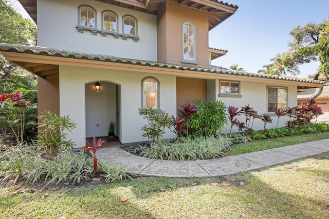 mediterranean / spanish house featuring a tiled roof and stucco siding