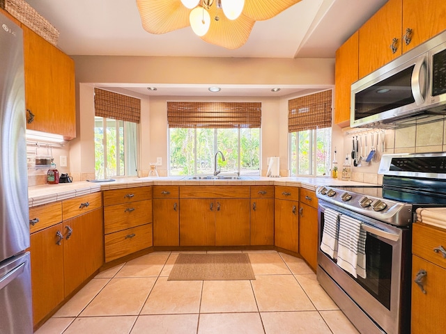 kitchen with appliances with stainless steel finishes, plenty of natural light, a sink, and decorative backsplash