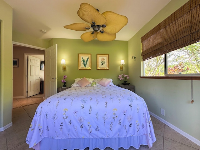 bedroom featuring baseboards, a ceiling fan, and light tile patterned flooring