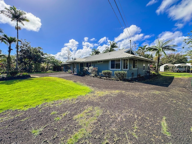 view of front of house featuring a front yard, metal roof, and driveway