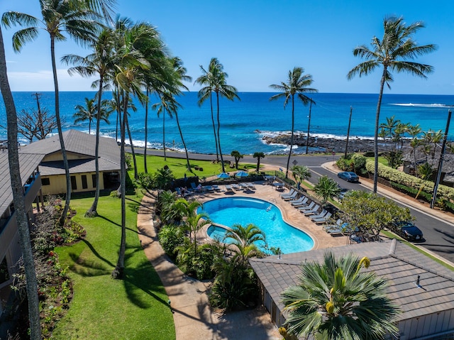 community pool featuring a yard, a patio, and a water view