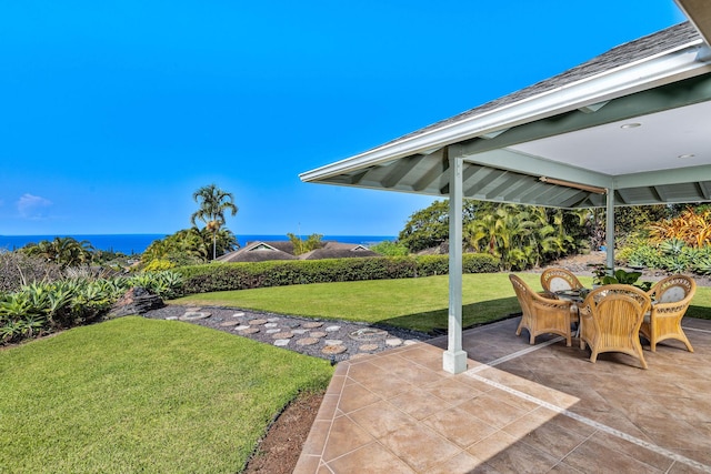 view of yard with outdoor dining area, a patio, and a water view