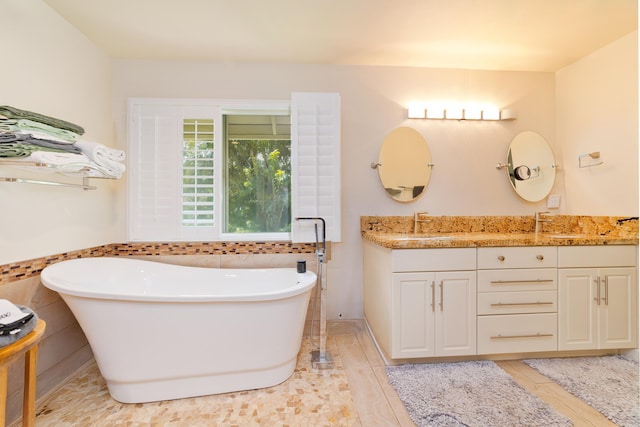 full bathroom featuring a freestanding bath and vanity