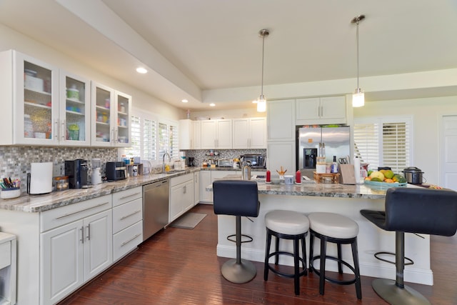 kitchen featuring stainless steel appliances, glass insert cabinets, and white cabinets