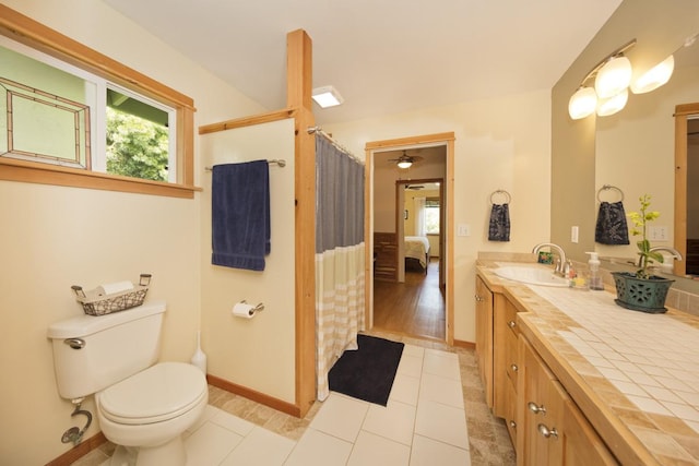 bathroom featuring baseboards, vanity, toilet, and tile patterned floors