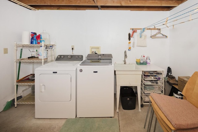 clothes washing area featuring independent washer and dryer and a sink